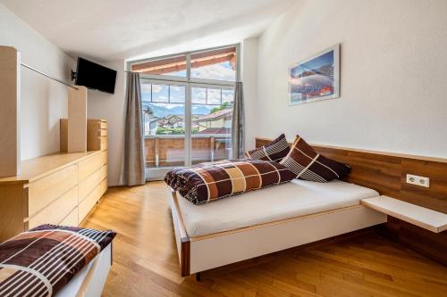 1 dormitorio con cama y ventana grande en Haus Rudi, en Ried im Zillertal