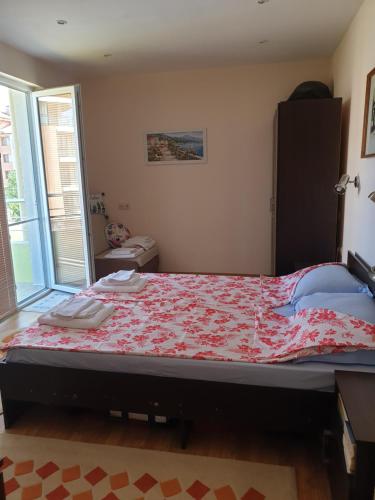 um quarto com uma cama grande e um edredão vermelho em апартамент в Приморско em Primorsko