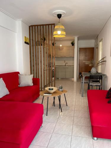 a living room with two red couches and a table at DM home (sea view apartment) in Lefkandi Chalkidas