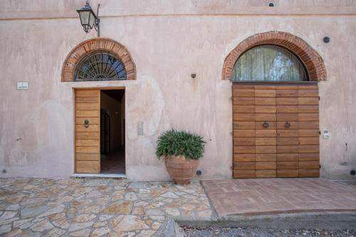 a building with two wooden doors and a potted plant at Appartamento Pianosa in Riotorto