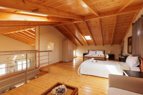 a bedroom with a bed in a room with wooden ceilings at Mythos Modern Loft in Dassia