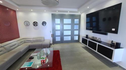 uma sala de estar com um sofá e uma televisão de ecrã plano em Villa Luxury - Finest luxury villa in Sosua & Puerto Plata em Juan de Nina Muñoz