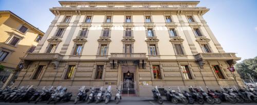 eine Gruppe von Motorrädern, die vor einem Gebäude geparkt sind in der Unterkunft Lilium Hotel in Florenz