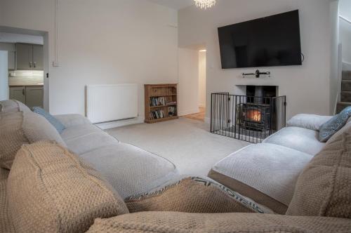 a living room with four couches and a fireplace at West Jordanston Farm Cottage - 4 Bedroom Cottage - St Florence in Tenby