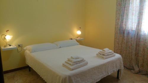 1 dormitorio con 1 cama con toallas en Appartamento titina, en Jerzu