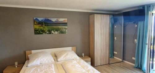 a bedroom with a bed and a painting on the wall at Ferienwohnung März in Seebruck