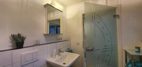 a white bathroom with a sink and a shower at Ferienwohnung März in Seebruck