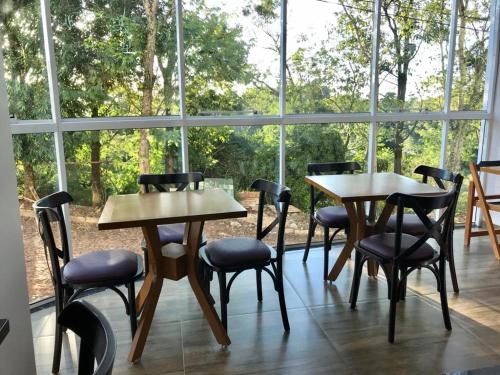 a group of tables and chairs in a room with a window at Hotel Ametista in Ametista do Sul