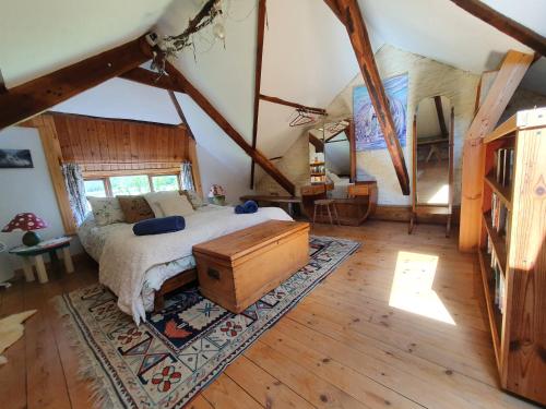 a bedroom with a bed and a wooden floor at Stable Cottage "The Unicorn Stable" in Yelverton