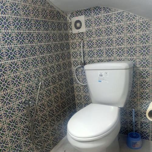 a bathroom with a white toilet in a room at Dar Tata in Nabeul