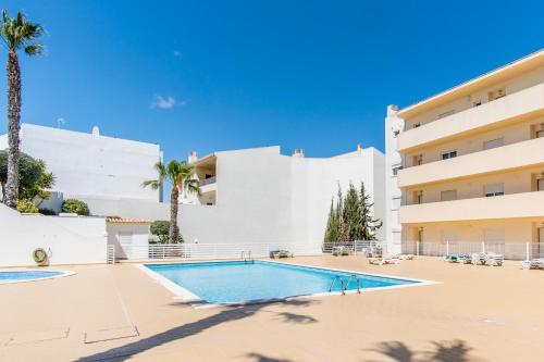 a swimming pool in front of a building with palm trees at #055 São José V by Home Holidays in Branqueira