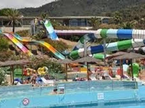 un toboggan aquatique dans une piscine avec des gens dans l'établissement Maison moderne 4 pièces climatisée, proche plage, avec jardin, terrasse couverte et parkings sécurisés - FR-1-226-279, à Sainte-Maxime