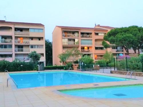 une piscine devant un immeuble dans l'établissement Appartement à Sainte-Maxime: 3 Pièces, Terrasse, Piscine, Clim, Proche Plage - FR-1-226-340, à Sainte-Maxime