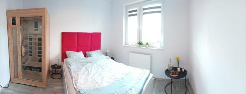 um quarto com uma cama com uma cabeceira vermelha em Apartament z Jacuzzi i Sauna em Radom