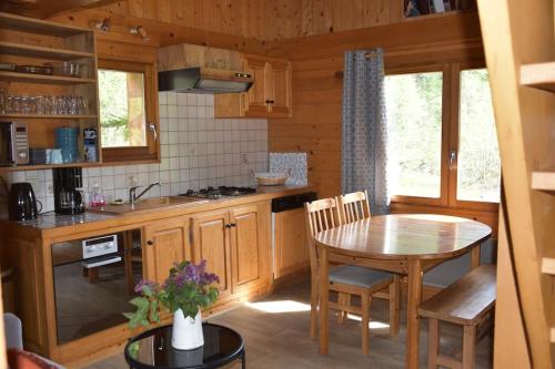 a kitchen with a table and a dining room table at Chalet L'Armoy in La Giettaz