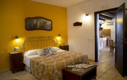 a bedroom with a bed and a yellow wall at B&B Sabir in San Vito lo Capo