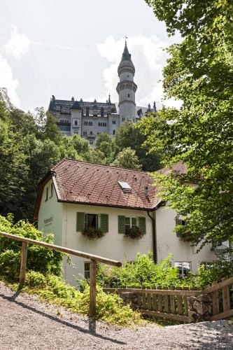 a building with a clock tower in the background at Schlossrestaurant Neuschwanstein in Hohenschwangau