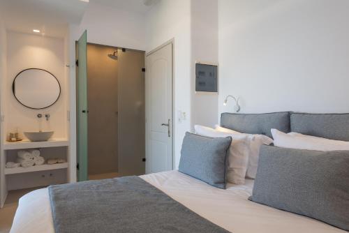 a bedroom with a bed with a sink and a mirror at Hotel Senia - Onar Hotels Collection in Naousa