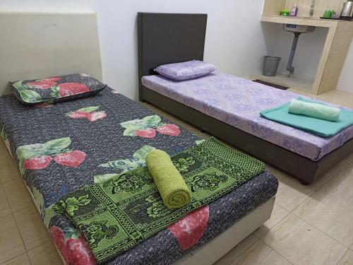 duas camas sentadas uma ao lado da outra num quarto em Depulauserai Roomstays em Pekan