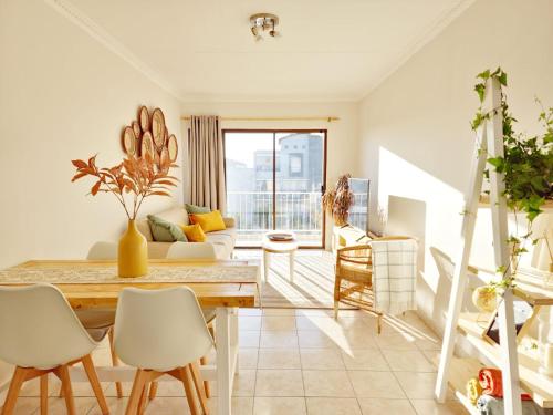 sala de estar con mesa, sillas y sofá en Villa Nordica - 2 bedroom self-catering apartment, en Ciudad del Cabo