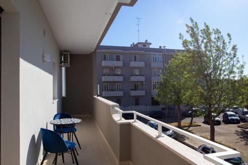 a balcony with two chairs and a table and a building at ARMONIE Salesiani Lecce in Lecce