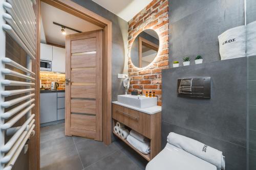 a bathroom with a sink and a brick wall at Saint Florian's Suites - Old Town Luxury Apartments - by Upstairs in Kraków