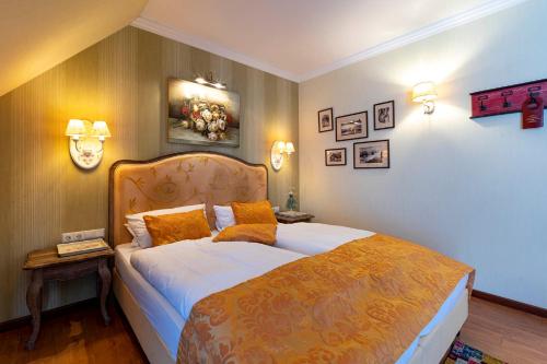 a bedroom with a large bed with orange pillows at Landhaus Wremer Deel in Wremen