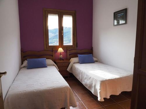 two beds in a room with purple walls and windows at Casa Tomaso - Turismo Rural in Reperos