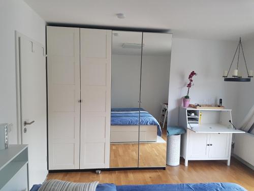 um quarto com um armário de vidro e uma cama em Zimmer mit eigenem Bad in Märchenstadt! em Heidelberg