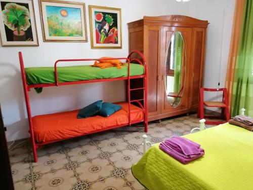 a bedroom with two bunk beds and a mirror at Casa Zagara in Favignana