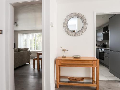a living room with a table and a mirror at 31 Beach Road in Porthmadog