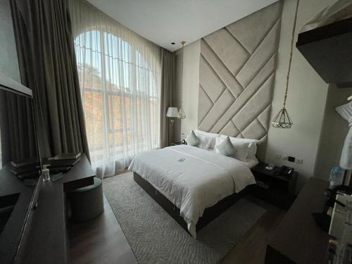 a bedroom with a bed and a large window at Sudfa Hotel in Taif