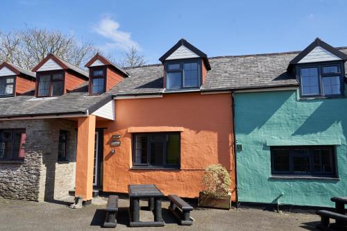 a building with a picnic table in front of it at Yetland Farm Holiday Cottages in Combe Martin