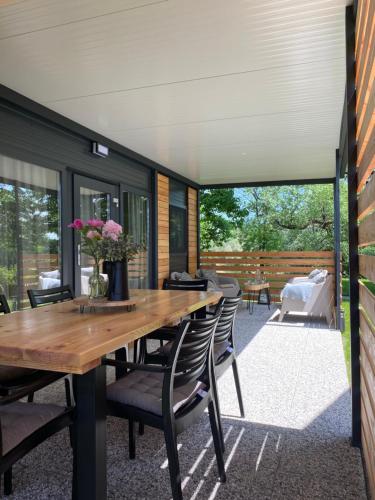 an outdoor dining room with a wooden table and chairs at MAGNOLIA HOUSE by the RIVER in Metlika