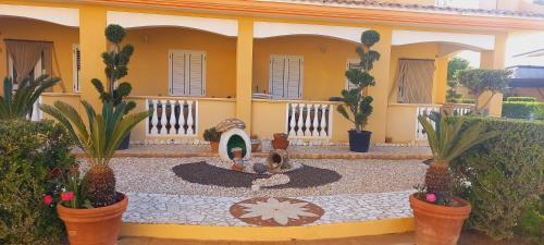 a house with a fountain in the middle of a courtyard at Villettemire in Capo Vaticano