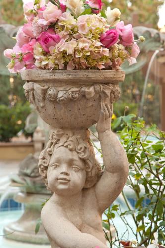 a statue of a child holding a pot of flowers at Azure Hotel&Suites Ontario Trademark Collection by Wyndham in Ontario