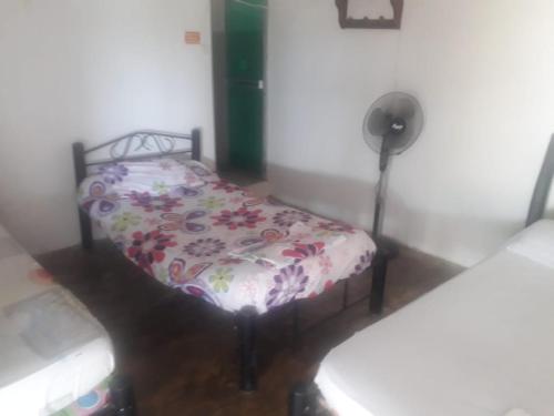 a bedroom with a bed with a floral comforter at Posada la tranquilidad in Villavieja