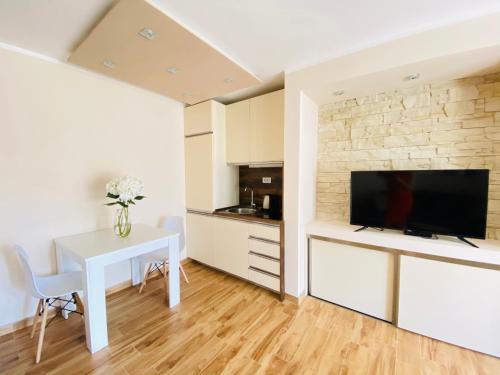 a living room with a white table and a tv at Villa Blanca in Risan