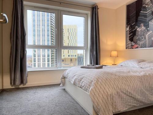 una camera con un letto e una grande finestra di LUXURY APARTMENT, SAUNA, GYM, 24hrs Concierge a Woking
