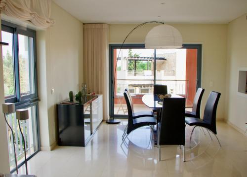 een eetkamer met een tafel en stoelen bij Victoria Gardens Luxury Apartment in Quarteira