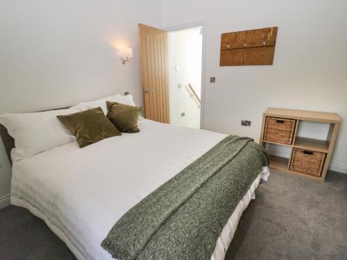 ein Schlafzimmer mit einem großen weißen Bett und einem Tisch in der Unterkunft Old Stone Cottage in Harrogate