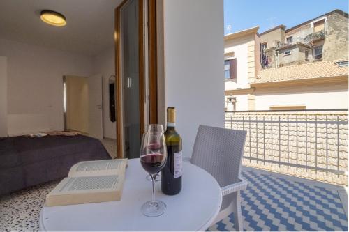 a table with a bottle of wine and a glass at Neva Suites Massa Lubrense Sorrento Coast in Massa Lubrense