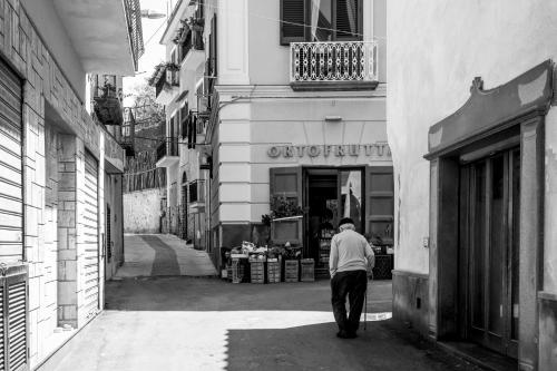 a man walking down a street in front of a store at Neva Suites Massa Lubrense Sorrento Coast in Massa Lubrense