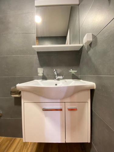 a bathroom with a white sink and a mirror at Villa Blanca in Risan
