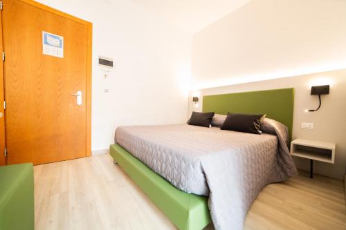 a bedroom with a large bed with a green headboard at All'Orologio - Boutique Hotel in Caorle