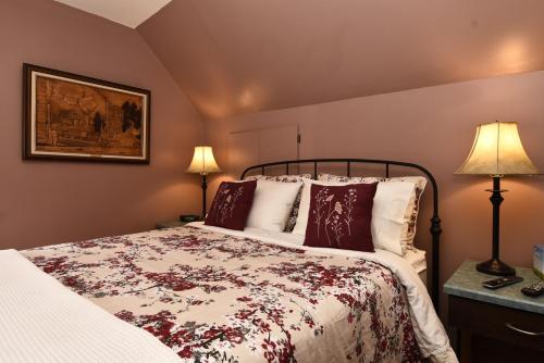 um quarto com uma cama grande e almofadas vermelhas e brancas em Phoenix House B&B em Stettler