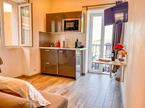 uma cozinha com um frigorífico de aço inoxidável e uma janela em Les Studios du Pêcheur - Hypercentre - Clim - City Trip em Ajaccio