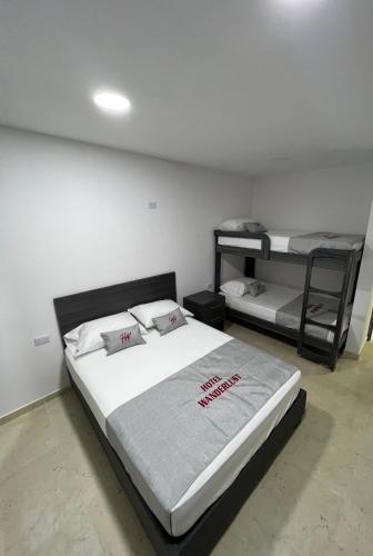 a bedroom with two beds and two bunk beds at Hotel Wanderlust in Santa Marta