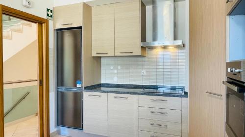 a kitchen with white cabinets and a stainless steel refrigerator at Santa Maria N by Check-in Portugal in Albufeira