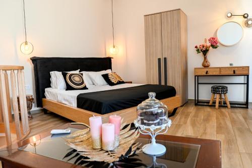 1 dormitorio con cama y mesa de cristal con velas en Residence by Georgia Studios en Fira
